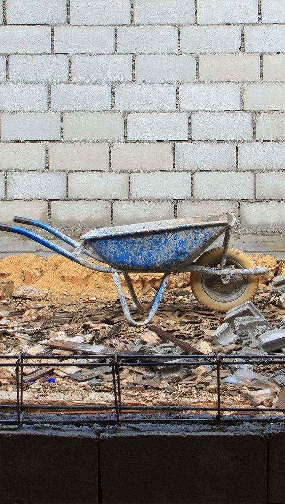Old rusty wheelbarrow in construction site